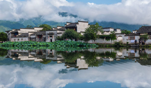 Buildings in town against cloudy sky