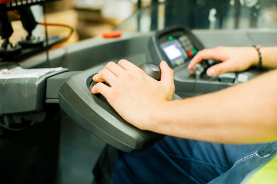 Cropped image of worker driving forklift in factory