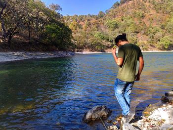 Man standing by lake against mountain