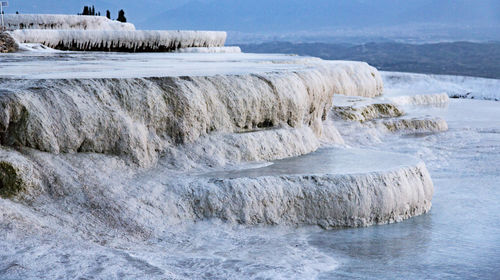 Rocks in sea against sky during winter