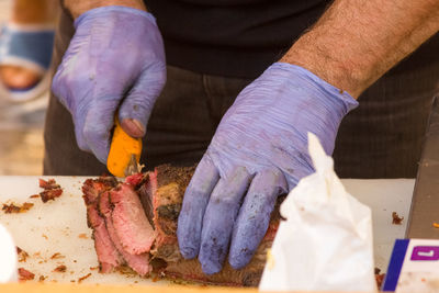 Close-up of man preparing food on barbecue grill
