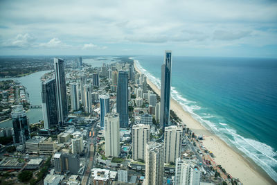 High angle view of modern buildings by sea against sky