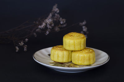 Close-up of fruits in plate on table against black background