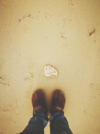 Low section of man standing on sand