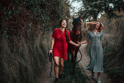 Full length of women walking with horse