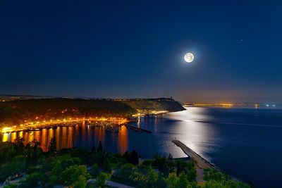 Illuminated sea against sky at night