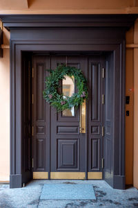 The wooden entrance door is decorated with a christmas wreath