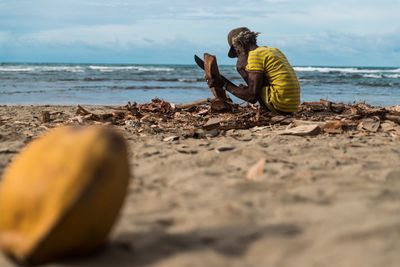 Boy on beach against sky