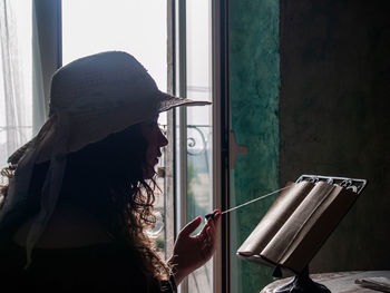 Woman reading book while sitting at home