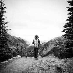 Rear view of man walking on mountain against sky