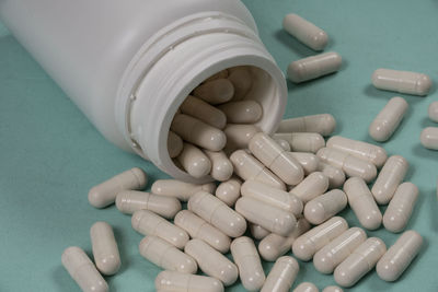 Close-up of pills spilling from bottle