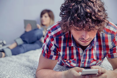 Close-up of young man using mobile phone while sitting on sofa at home