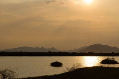 Scenic view of lake against sky during sunset