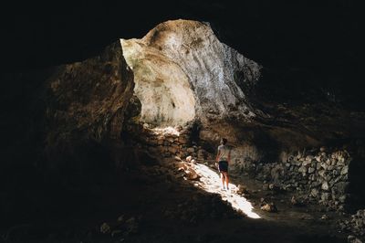 Rear view of man standing in cave