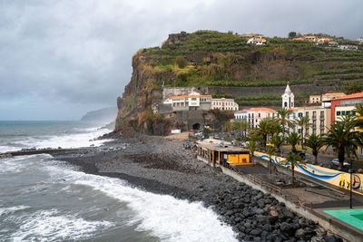 Scenic view of beach against cloudy sky