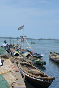 Boats moored on sea against sky