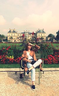 Portrait of smiling woman sitting against built structure