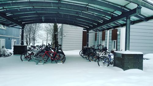 Bicycle parked against building during winter