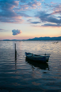Sailboats in sea against sky during sunset