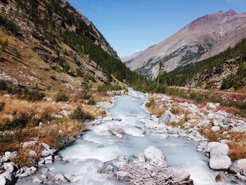 Scenic view of river amidst mountains against sky