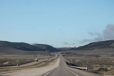 Road passing through landscape against clear sky