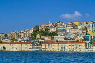 Buildings by sea against sky