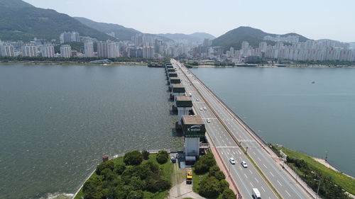 High angle view of city by sea against sky