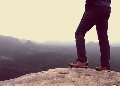 Low section of man standing on mountain