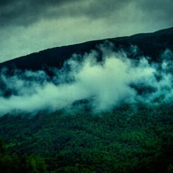 Scenic view of mountains against cloudy sky