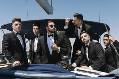 Elegant men looking away on yacht during summer