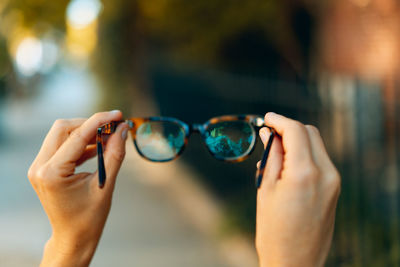 Close-up of human hand holding sunglasses
