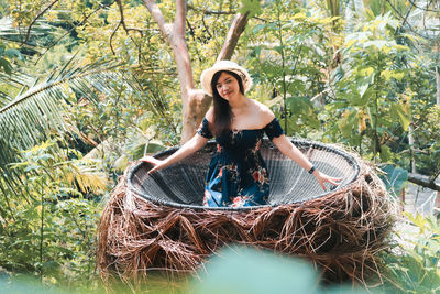 Portrait of woman sitting in wicker container