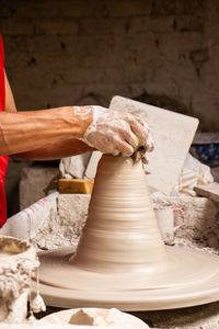 Midsection of potter working at workshop