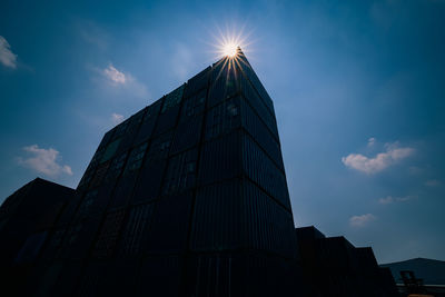  shipping container with sun flair light blue sky  wide angle view shot darkened shadow tone