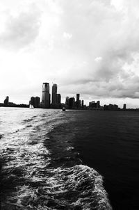 Buildings by sea against sky in city
