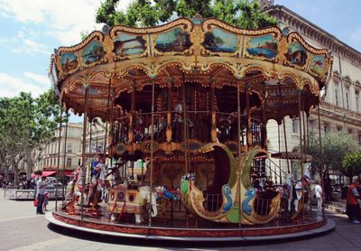 Carousel in amusement park against sky