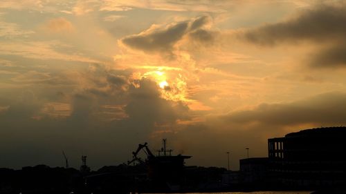 View of city against cloudy sky at sunset