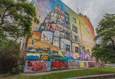 Low angle view of graffiti on building against sky