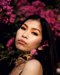 Portrait of beautiful woman with pink flower