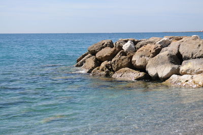 Rocks in sea against sky