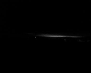 Silhouette of light against sky at night