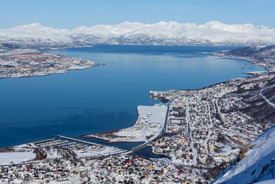 High angle view of cityscape by sea against sky