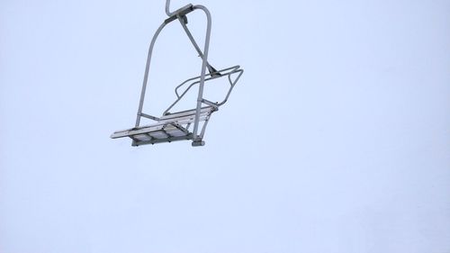 Low angle view of chairlift against foggy sky