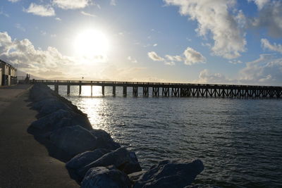 Pier on sea at sunset