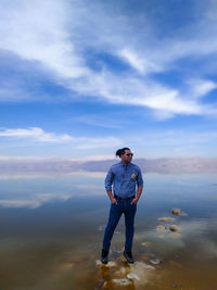 Full length of young man standing against sky