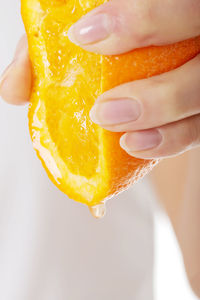 Close-up of hand squeezing orange