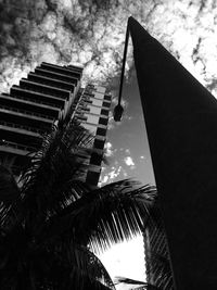 Low angle view of modern building against cloudy sky