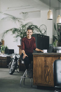 Portrait of young man sitting on table