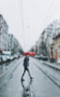 Cars on road seen through wet window