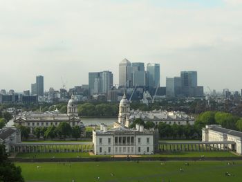 View of cityscape against cloudy sky